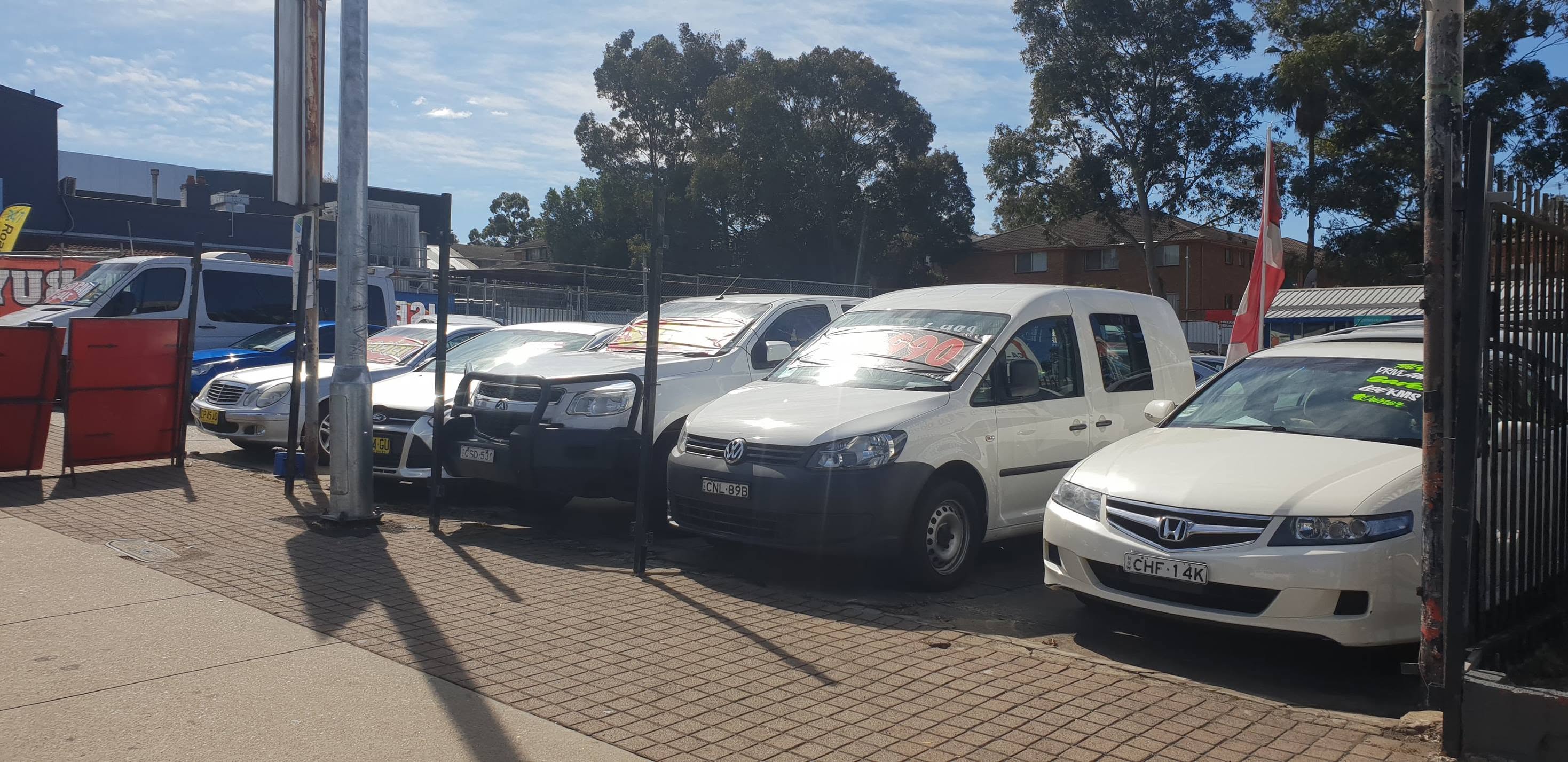 The kerbside row: a white Honda Accord Euro, a Volkswagen Caddy van and a Toyota HiLux with a bullbar